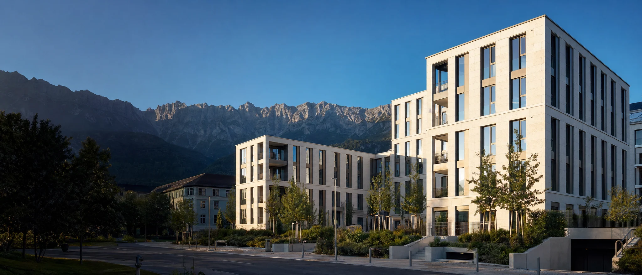 Beispielmotiv: moderne helle Gebäude vor einer Tiroler Bergkulisse